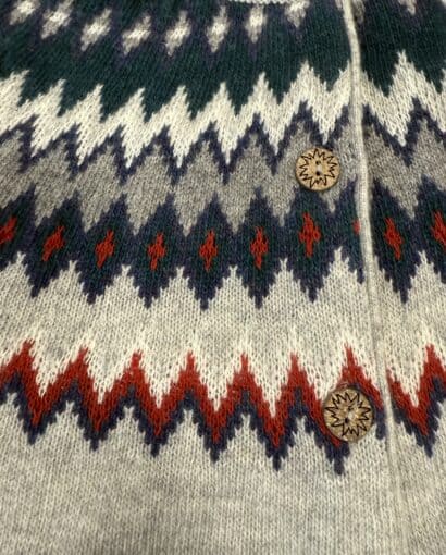 Donna indossa un cardigan in lana con motivo jacquard colorato, perfetto per look autunnali e invernali, disponibile presso Maglificio Annamaria.