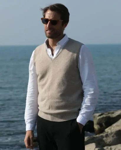 Vestito uomo elegante con maglione e camicia, in un ambiente marino.
