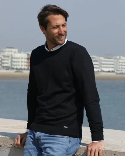 Maglificio Annamaria, produzione di maglieria di alta qualità, presenta un uomo che indossa un elegante maglione nero, perfetto per uno stile casual e raffinato.