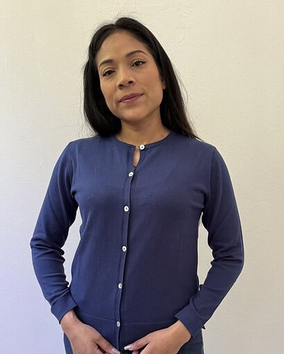 Donna che indossa un cardigan blu in maglificio artigianale, perfetto per uno stile elegante e confortevole.