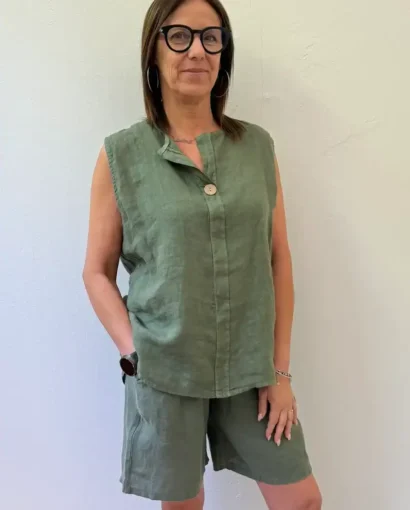 Vestito estivo in lino verde con tasche, donna con occhiali, look casual chic perfetto per la stagione calda.