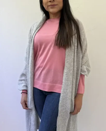 Donna con maglione rosa e cardigan grigio, abbigliamento di alta qualità dal Maglificio Annamaria, specializzato in maglieria artigianale italiana.