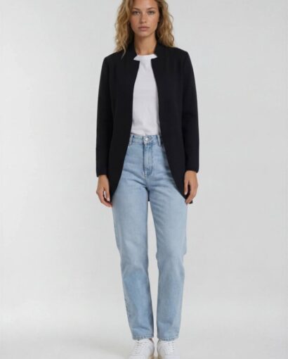Donna indossa un completo casual con giacca nera, t-shirt bianca e jeans chiari, moda elegante e confortevole da Maglificio Annamaria.