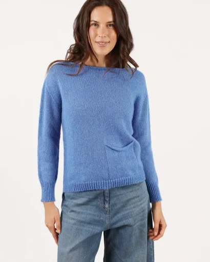 Donna indossa un maglione blu in lana di alta qualità, perfetto per l'inverno, con un design semplice e elegante, ideale per uno stile casual e raffinato.