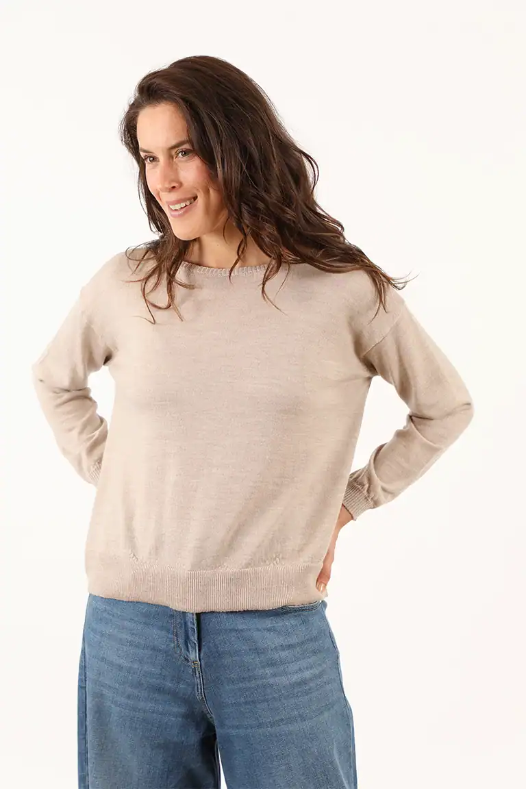 Donna indossa un maglione beige in cashmere di alta qualità da Maglificio Annamaria, perfetto per uno stile elegante e confortevole, con un look casual e sofisticato.