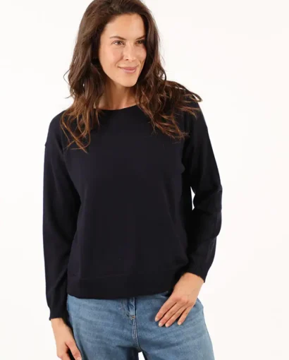 Donna indossa un maglione nero e jeans azzurri, moda casual elegante, Maglificio Annamaria, abbigliamento donna di qualità, stile italiano, comfort e raffinatezza.