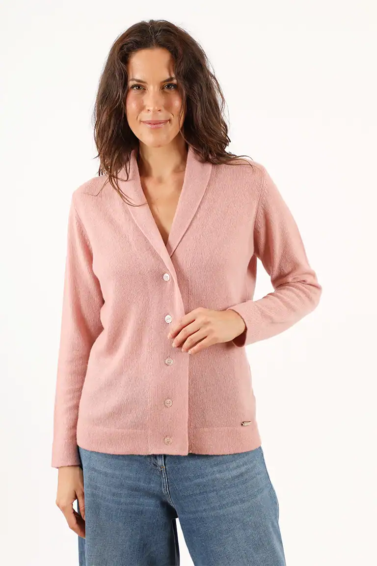 Donna indossa un cardigan rosa in lana di alta qualità, perfetto per look eleganti e casual, con dettagli di bottoni e vestibilità comoda, ideale per la moda autunnale e invernale.