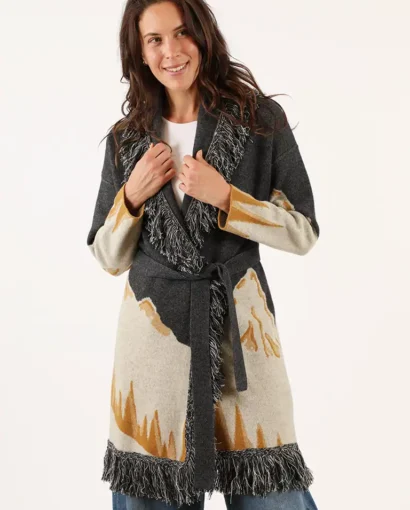 Donna indossa un cappotto in lana con motivo astratto in beige, grigio e nero, con frange sul bordo, perfetto per l'inverno, da Maglificio Annamaria.
