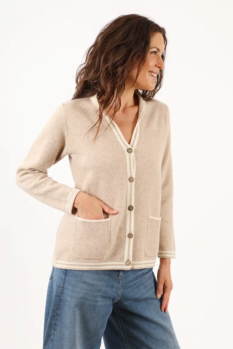 Donna indossa un cardigan beige con bottoni e tasche, abbigliamento elegante e confortevole, perfetto per look casual e sofisticati, prodotto dal Maglificio Annamaria.