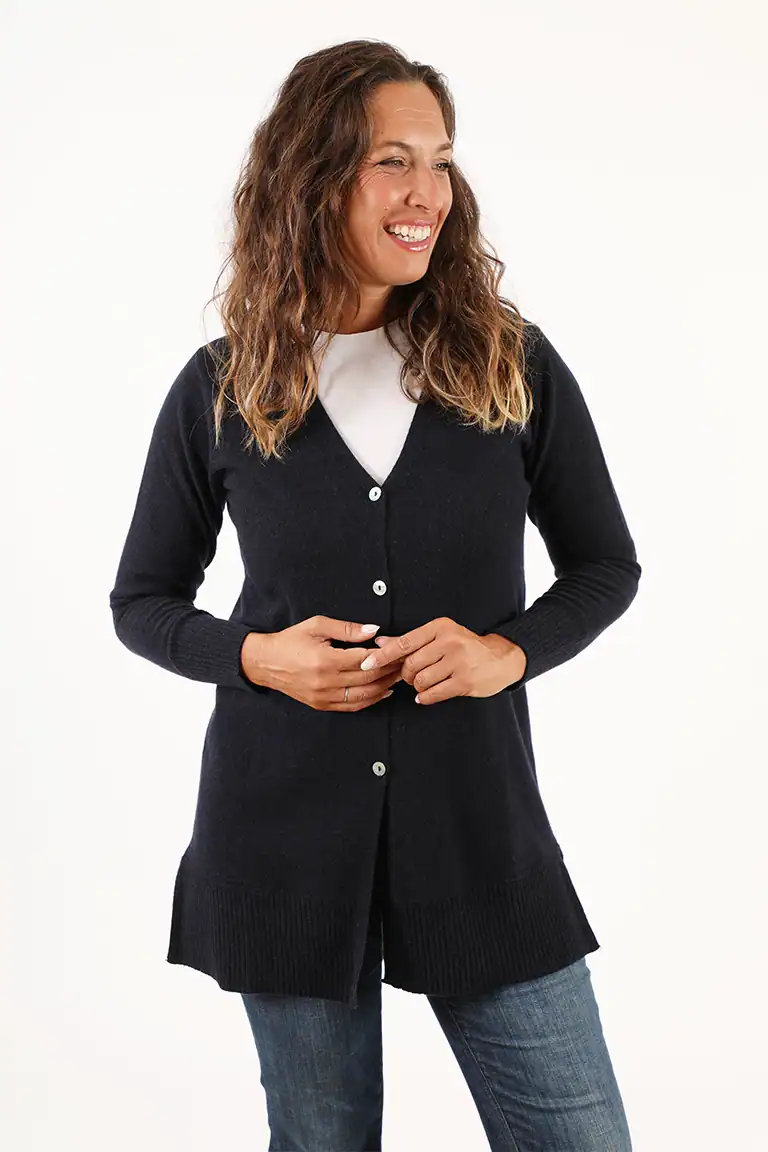 Donna sorridente indossa un cardigan nero lungo con bottoni, ideale per look eleganti e casual, in un'immagine promozionale di Maglificio Annamaria.