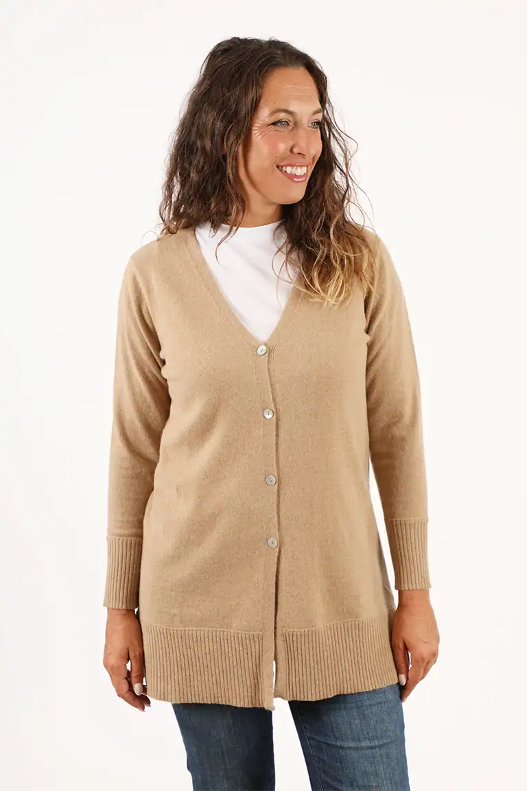 Donna indossa un cardigan beige in cashmere di Maglificio Annamaria, abbigliamento di alta qualità per un look elegante e confortevole.