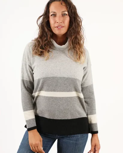 Donna indossa un maglione color block beige, marrone e crema, in stile casual, perfetto per l'autunno, con un sorriso e look naturale, rappresentando la moda di Maglificio Annamaria.