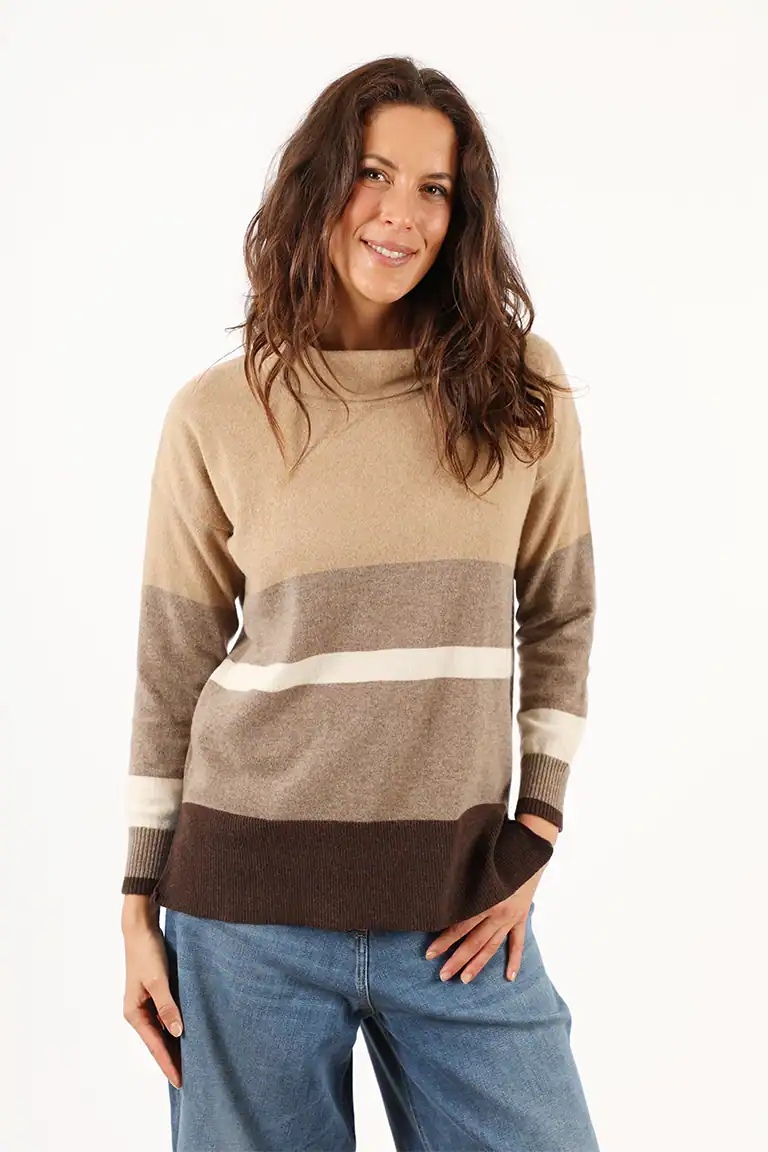 Donna indossa un maglione color block beige, marrone e crema, in stile casual, perfetto per l'autunno, con un sorriso e look naturale, rappresentando la moda di Maglificio Annamaria.