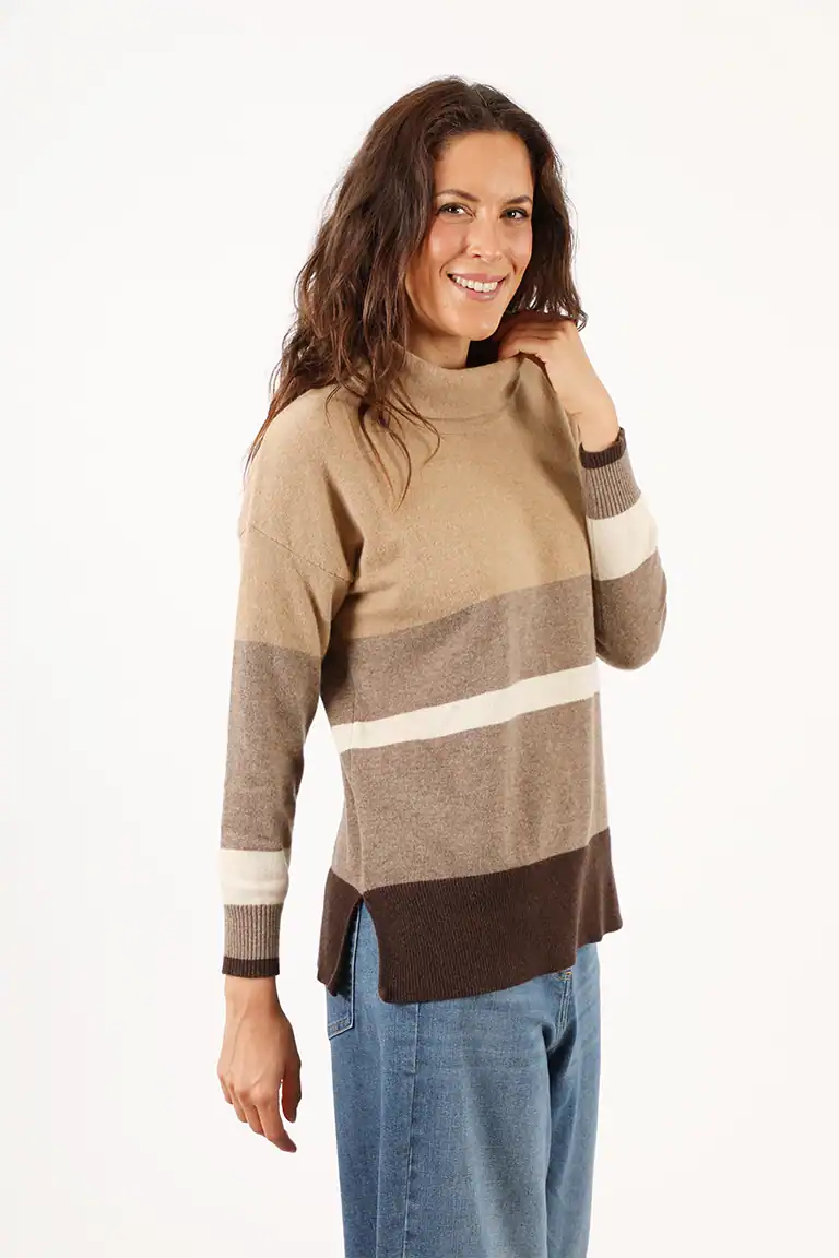 Donna indossa un maglione a righe beige, marrone e bianco, stile casual e confortevole, perfetto per l'autunno, presso Maglificio Annamaria.