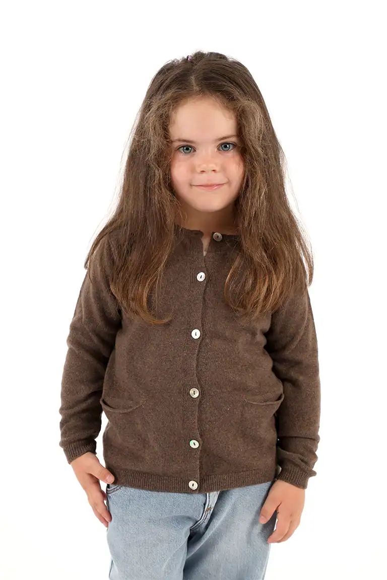Bambina con maglione marrone e jeans chiari, abbigliamento di alta qualità del Maglificio Annamaria, ideale per bambini, moda e comfort.