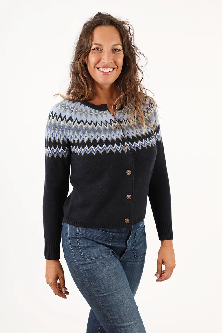 Donna indossa un maglione in lana con motivo a zigzag blu, grigio e nero, perfetto per l'inverno, in stile casual e elegante, prodotto dal Maglificio Annamaria.