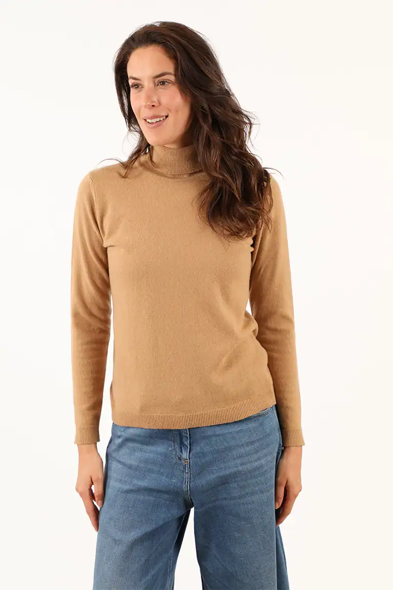 Donna indossa un maglione beige e jeans blu, moda autunnale elegante e confortevole, ideale per look casual e chic, prodotto dal Maglificio Annamaria.