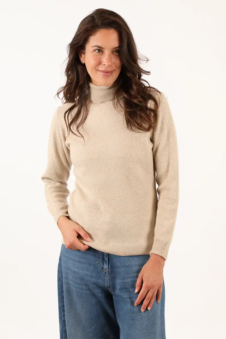 Donna con maglione beige a collo alto e jeans blu, moda autunnale elegante e confortevole, Maglificio Annamaria.