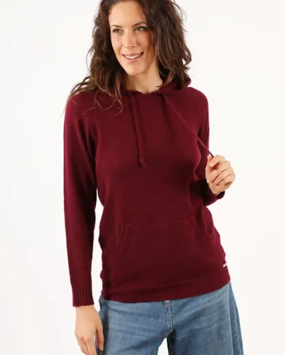 Donna indossa un maglione rosso a maniche lunghe con cappuccio e tasca frontale, perfetto per look casual e autunnali, di Maglificio Annamaria.