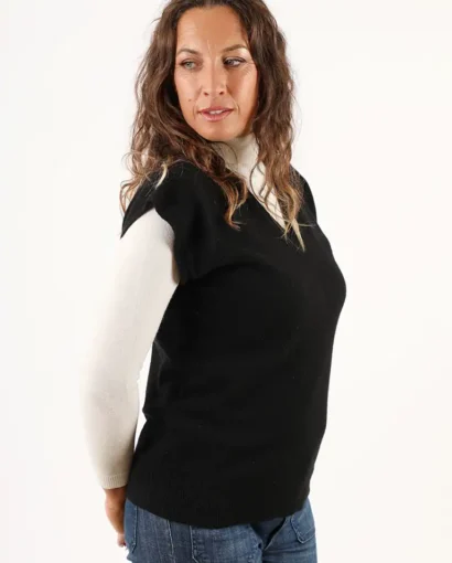 Donna indossa un maglione nero e bianco, moda autunno-inverno, abbigliamento di alta qualità, Maglificio Annamaria, stile elegante e confortevole, produzione italiana di maglieria.