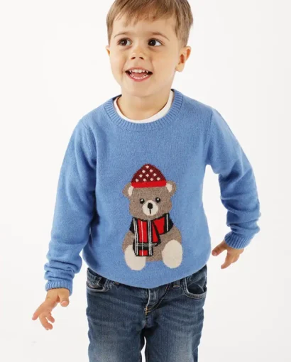 Bambino che indossa un maglione azzurro con orsetto decorativo e cappello rosso, ideale per abbigliamento bambino di qualità da Maglificio Annamaria.