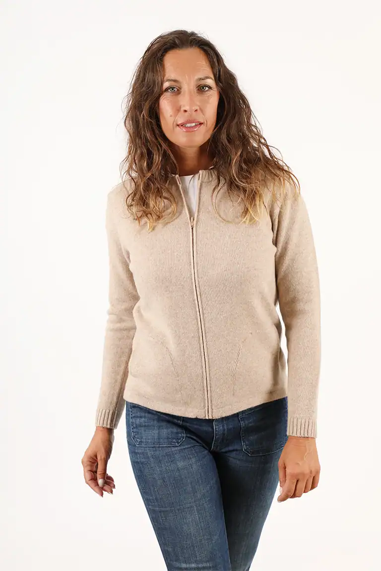 Donna indossa un cardigan beige in maglificio artigianale, perfetto per uno stile casual ed elegante, con dettagli di alta qualità e comfort superiore.