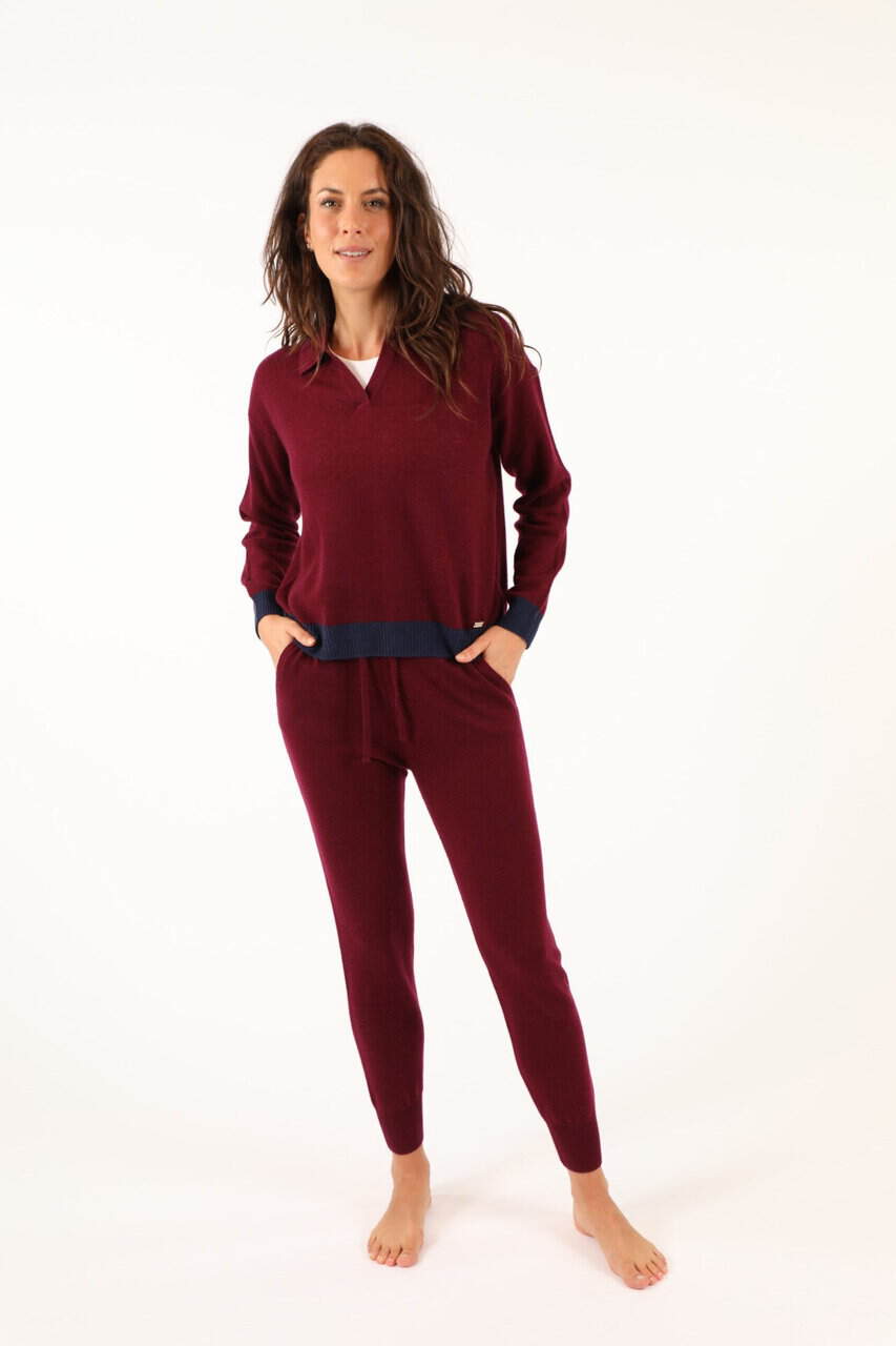 Donna indossa un completo di maglificio in maglia rossa con dettagli blu, perfetto per look casual e confortevoli, ideale per l'inverno. Maglificio Annamaria, qualità e stile.