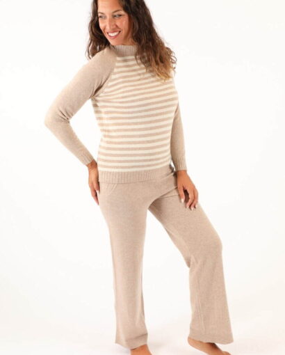 Donna indossa un completo di maglificio in lana beige con righe, abbigliamento elegante e confortevole di Maglificio Annamaria, perfetto per look casual e sofisticati.